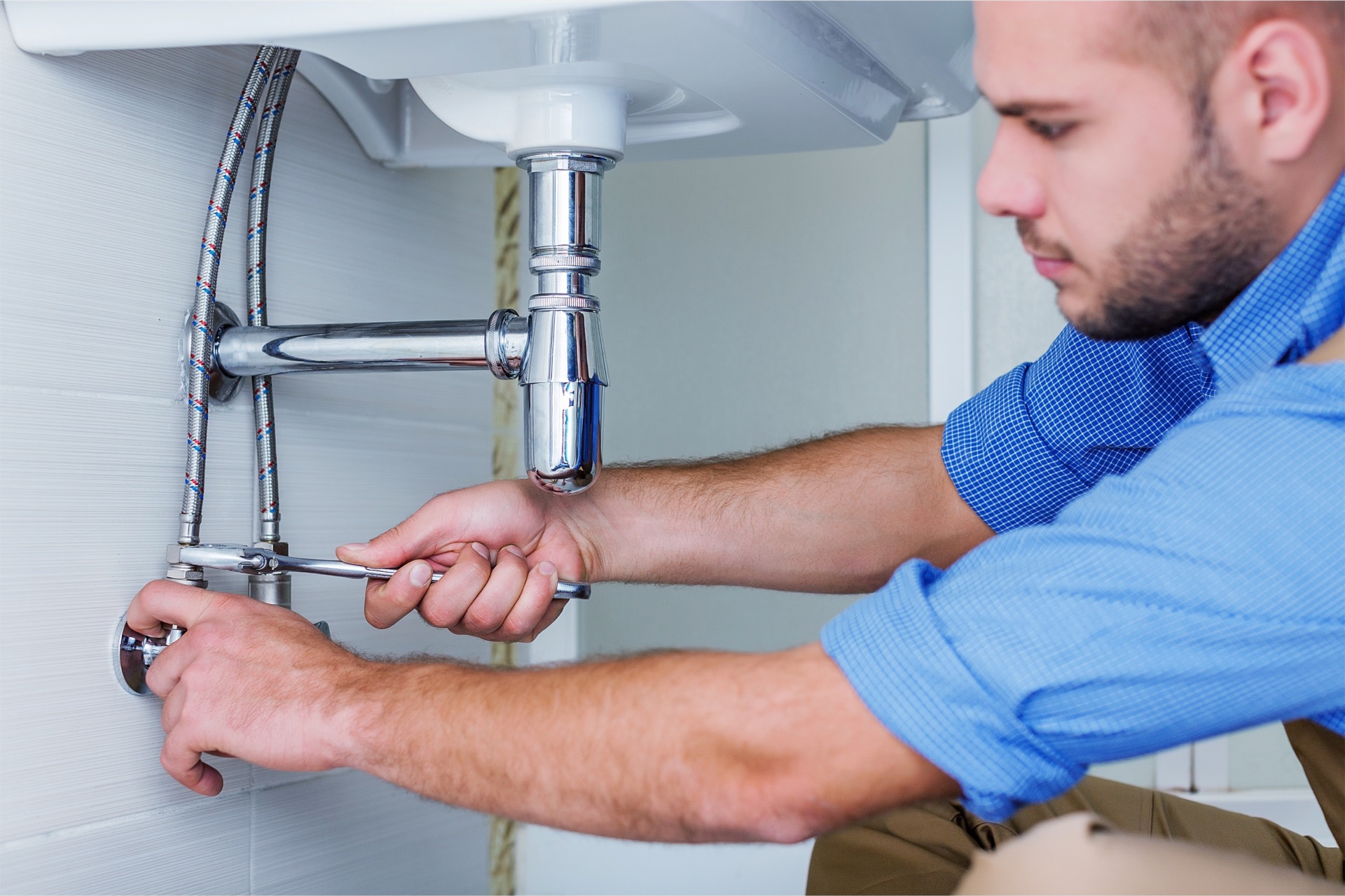 Property manager fixing sink plumbing